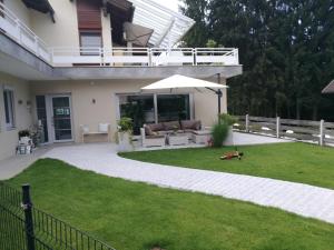 a patio with an umbrella and a lawn at Ferienwohnung Urlaubsfreude für 2 bis 7 Personen in Paternion
