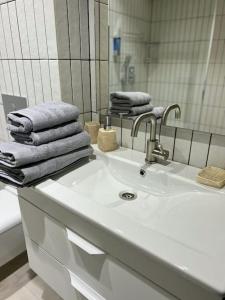 W łazience znajduje się biała umywalka i lustro. w obiekcie 2 bedroom on Ismail corner Stefan cel Mare, new apartment, Chisinau center! w Kiszyniowie
