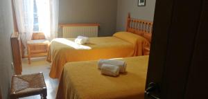 a hotel room with two beds with towels on them at Hostal Los Valles in Bielsa