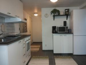 a kitchen with white cabinets and a white refrigerator at Lägenhet Lillisgården in Vallåkra