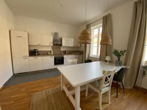 cocina blanca con mesa blanca y sillas en Wohnung in Bayreuths schönster Straße en Bayreuth