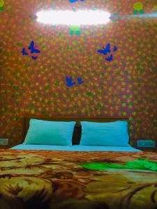 ein Schlafzimmer mit einem Bett mit blauen Vögeln an der Wand in der Unterkunft Vamoose Thakurji Palace in Jaisalmer