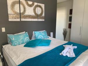 un letto con cuscini blu e un asciugamano. di City Penthouse Kapstadt a Città del Capo