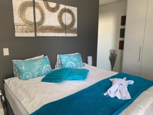 a bed with blue pillows and a towel on it at City Penthouse Kapstadt in Cape Town