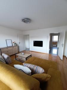 a living room with a couch and a tv at Apartment Waldblick - 77 qm, 2 Schlafzimmer, Balkon und Wi-Fi in Maulburg