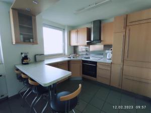 - une cuisine avec des placards en bois, une table et des chaises dans l'établissement Apartment Waldblick - 77 qm, 2 Schlafzimmer, Balkon und Wi-Fi, à Maulburg