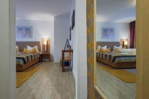Habitación de hotel con 2 camas y espejo en Franconia City Hotel en Núremberg