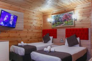 a bedroom with two beds and a tv on the wall at Ensar Apart in Uzungöl