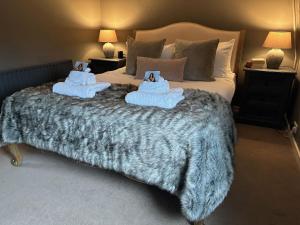 a bedroom with a large bed with two stuffed animals on it at Meadow Cottage in Salisbury