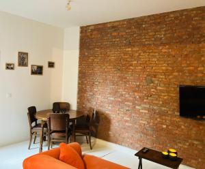 a living room with a brick wall and a table and chairs at BnB Suikernest in Antwerp