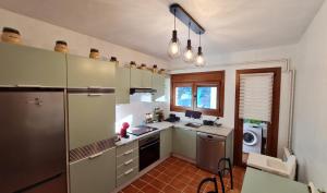 cocina con nevera, fregadero y lavavajillas en Apartament Vent de Port, en Vilaller