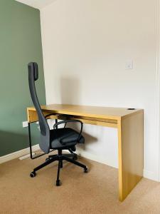 a desk with a black chair sitting in front of it at Mezzo House- Entire property in Coventry