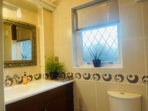 a bathroom with a sink and a window and a toilet at Super King Bed Suite, Executive office, fast WiFi, free parking in St. Ives