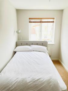 Cama blanca en habitación con ventana en Mezzo House- Entire property, en Coventry