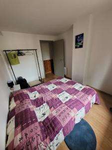 1 dormitorio con 1 cama con edredón morado en Repos au vert en Ariège, en Le Peyrat