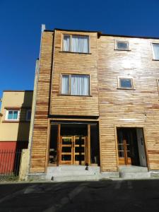 un edificio de madera con puertas que se abren en una calle en Aroma Verde Hotel, en Valdivia