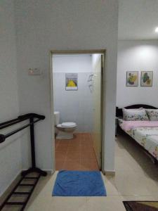 bagno con camera da letto con servizi igienici e letto di Dahliya Roomstay Langkawi a Pantai Cenang