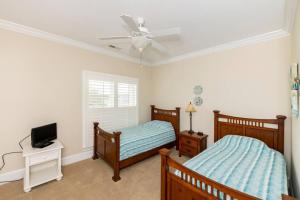 sypialnia z dwoma łóżkami i wentylatorem sufitowym w obiekcie Casa Coral 4 Bed 4 Bath with EV charging w mieście Kure Beach