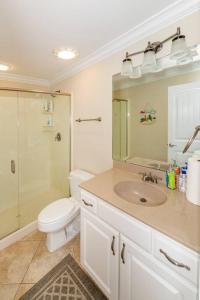 łazienka z toaletą, umywalką i prysznicem w obiekcie Casa Coral 4 Bed 4 Bath with EV charging w mieście Kure Beach +37 zdjęć