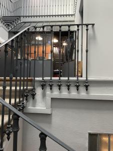 un escalier avec des balustrades noires dans un bâtiment dans l'établissement AppartsHotels'De Ville, à Bourg-lès-Valence