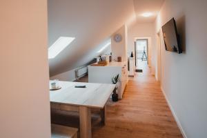 Casa con cocina y sala de estar con mesa de madera. en Working Apartment - 8 single beds - 5 Schlafzimmer, en Mönchengladbach