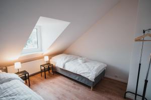a attic bedroom with two beds and two lamps at Working Apartment - 8 single beds - 5 Schlafzimmer in Mönchengladbach