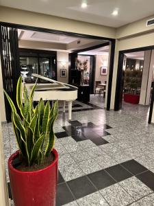 eine Topfpflanze in einer Lobby mit einem Billardtisch in der Unterkunft Hotel Comtur in Binasco