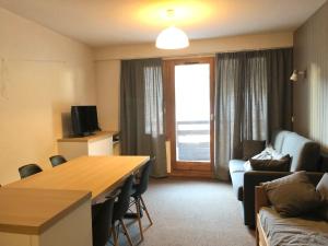 a living room with a table and a couch at FOLYERE 17 La Tania in La Tania