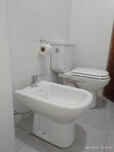 a white bathroom with a toilet and a sink at La Cabaña de Eco Verde in San Rafael