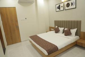 um quarto com uma cama e uma porta de madeira em Hotel Panch em Kalol