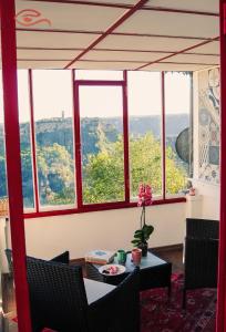 Zimmer mit einem Tisch, Stühlen und Fenstern in der Unterkunft MiraCivita in Lubriano