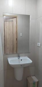 a bathroom with a white sink and a mirror at Condo Saga Davao City in Davao City