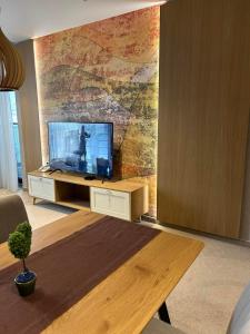 a living room with a tv on a wall at City Park Inn Apartment Verona in Plovdiv