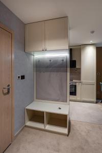 a kitchen with white cabinets and a large appliance at City Park Inn Apartment Verona in Plovdiv