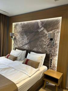 um quarto com uma cama grande e uma grande cabeceira. em City Park Inn Apartment Verona em Plovdiv