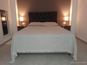 1 dormitorio con 1 cama grande con manta blanca en La Cabaña de Eco Verde en San Rafael