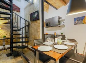 a dining room with a table and chairs and a spiral staircase at New Listing DUPLEX NEAR THE BEACH Barceloneta in Barcelona
