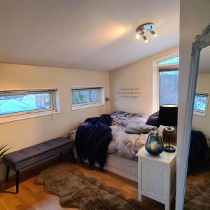 a bedroom with a bed and a bench and two windows at Sand Beachhouse in Sand