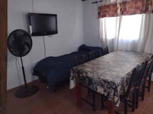 Habitación con mesa, TV, mesa y sillas. en Los jilgeros en Santa Rosa de Calamuchita