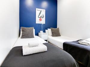 two beds in a room with blue walls at New Listing DUPLEX NEAR THE BEACH Barceloneta in Barcelona