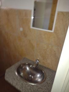 lavabo de plata en un baño con espejo en Los jilgeros en Santa Rosa de Calamuchita