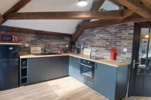 a kitchen with blue appliances and a brick wall at *NEW*Les Amandines le LOFT* WIFI in Allevard