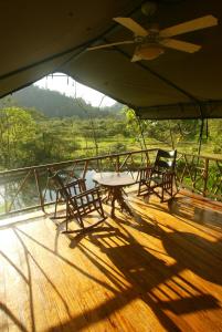 einen Tisch und Stühle auf dem Deck eines Bootes in der Unterkunft Rafiki Safari Lodge in Savegre