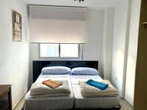 a bedroom with a bed with two pillows and a window at Alhambra Apartments in Granada