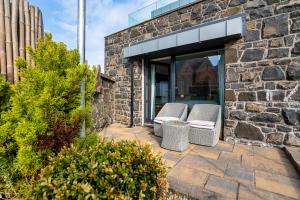 two wicker chairs sitting outside of a stone building at Antrim House Suites with private jacuzzi hot tub - adults only in Portrush