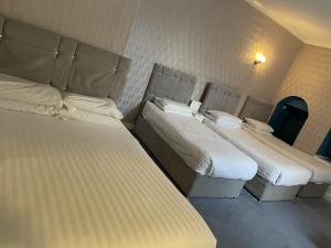 two beds in a hotel room with two bedsvisor at Diamonds Inn Ltd in York