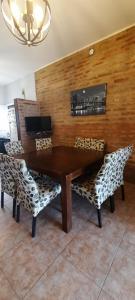 a wooden table with two chairs and a wooden wall at Casa quinta con pileta in Santa Rosa