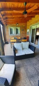 un patio con sofá, mesas y techo de madera. en Casa quinta con pileta en Santa Rosa