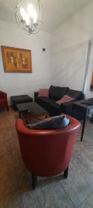 a living room with a couch and a red chair at Casa quinta con pileta in Santa Rosa