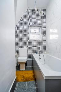 uma casa de banho com um WC, uma banheira e um lavatório. em Deluxe 2-Bedroom Flat with Free parking em Birmingham